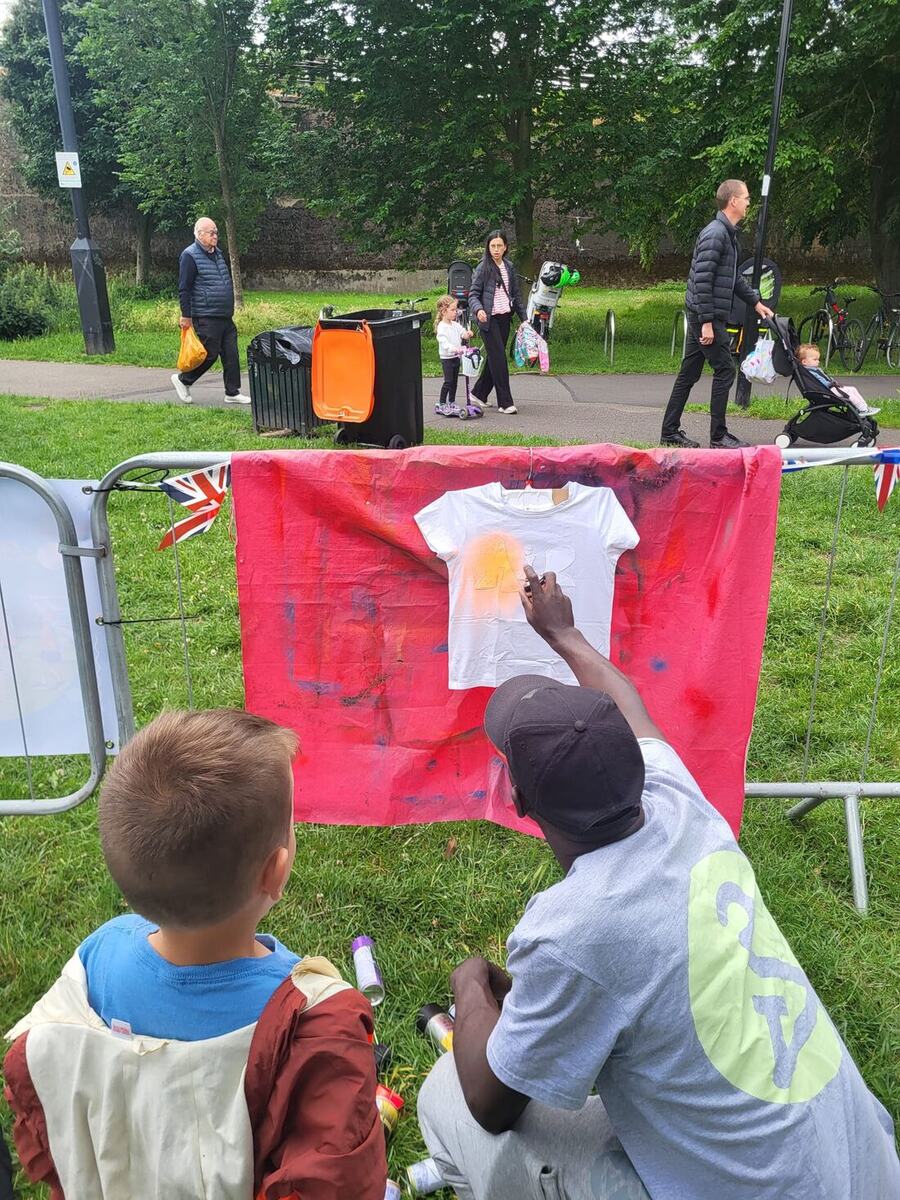 Spray painting a t-shirt at an outdoor session